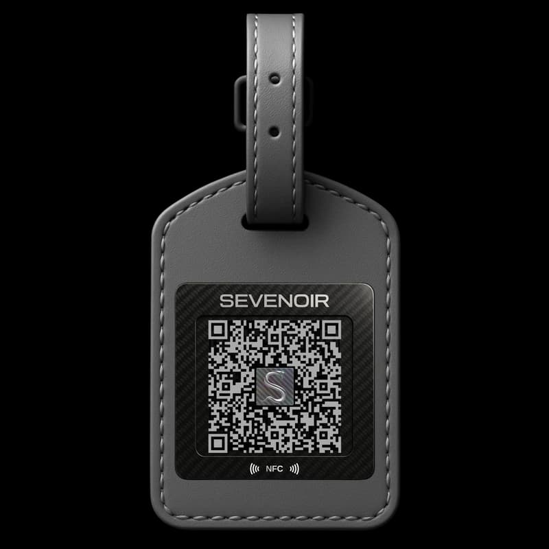 A Sevenoir luggage tag: a grey leather tag with a carbon-fibre panel carrying a QR code and an NFC mark.